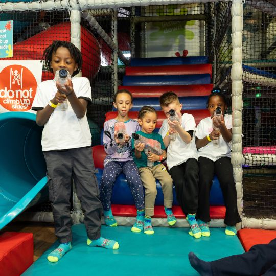 Children playing with laser tag toys at an indoor playground