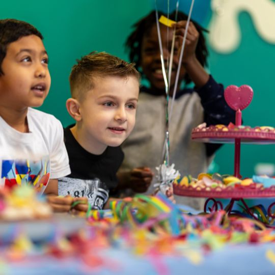 Children enjoying a colourful birthday party with decorations and treats
