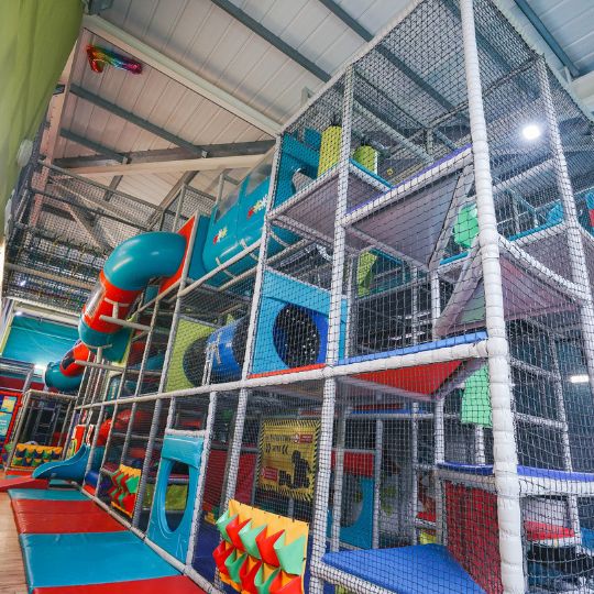 Colorful indoor playground with multi-level netted climbing structures