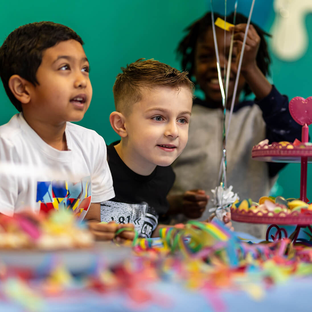 Children enjoying colorful birthday party with decorations and treats