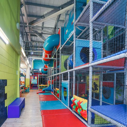 Colorful indoor children's playground with multi-level netted play structure