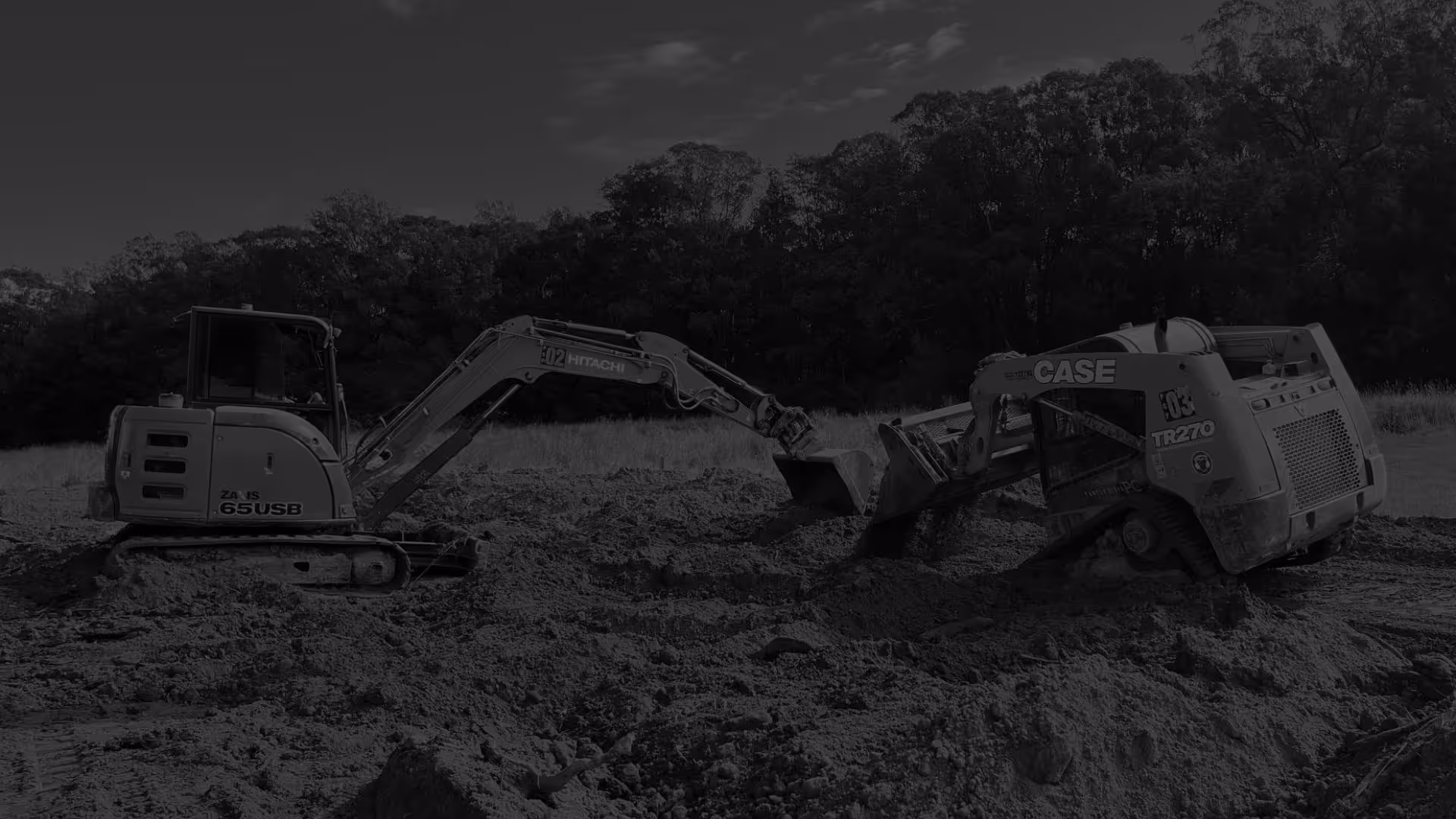 Excavator and skid steer machines facing each other