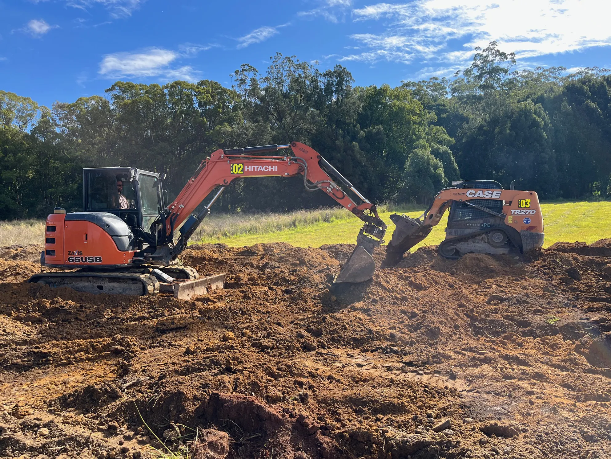 Orange excavator picking up dirt