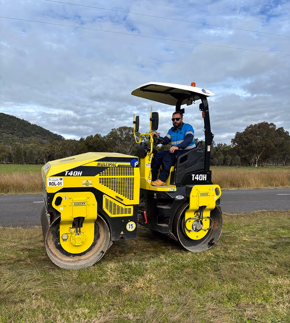 Man driving yellow drum roller machine