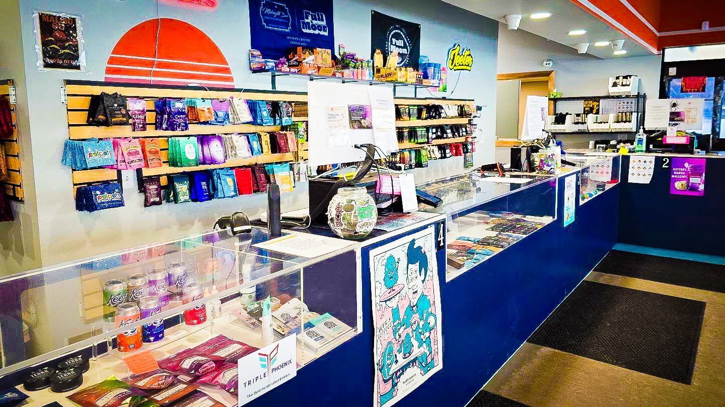 Interior of Sunset Coast Provisions dispensary featuring wooden display counters, a wide selection of cannabis strains, and a welcoming reception area.
