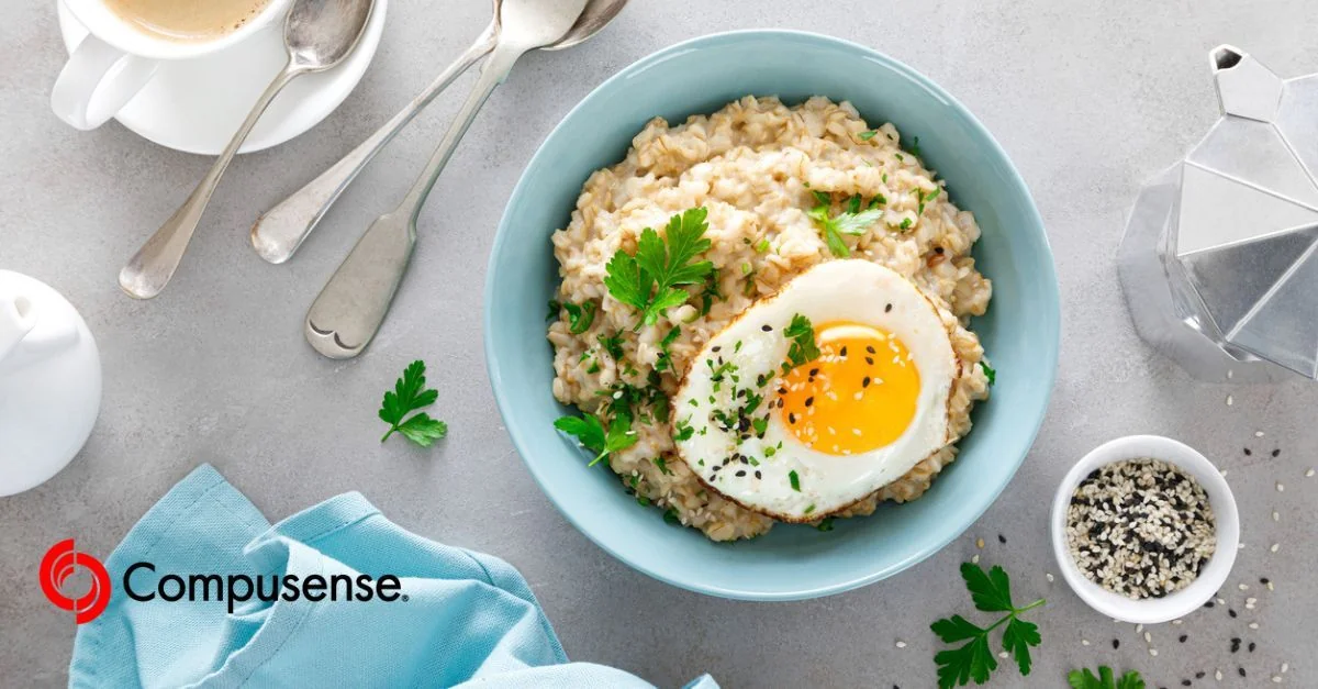 A vibrant bowl of ramen noodle soup topped with a soft-boiled egg, fresh herbs, and garnishes, served on a turquoise plate with chopsticks.