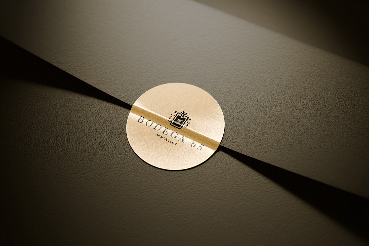 Etiqueta Bodega 65 en mockup adhesivo — diseño de packaging por Indigo Estudio Mallorca