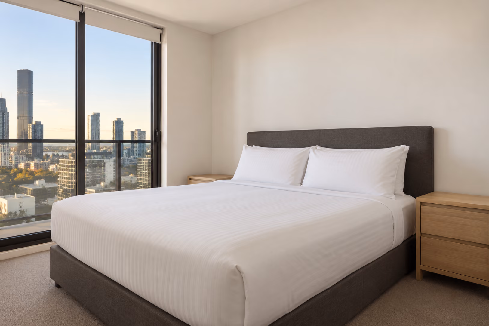 Airbnb bedroom before styling: bare bed, plain linen, no throws or pillows