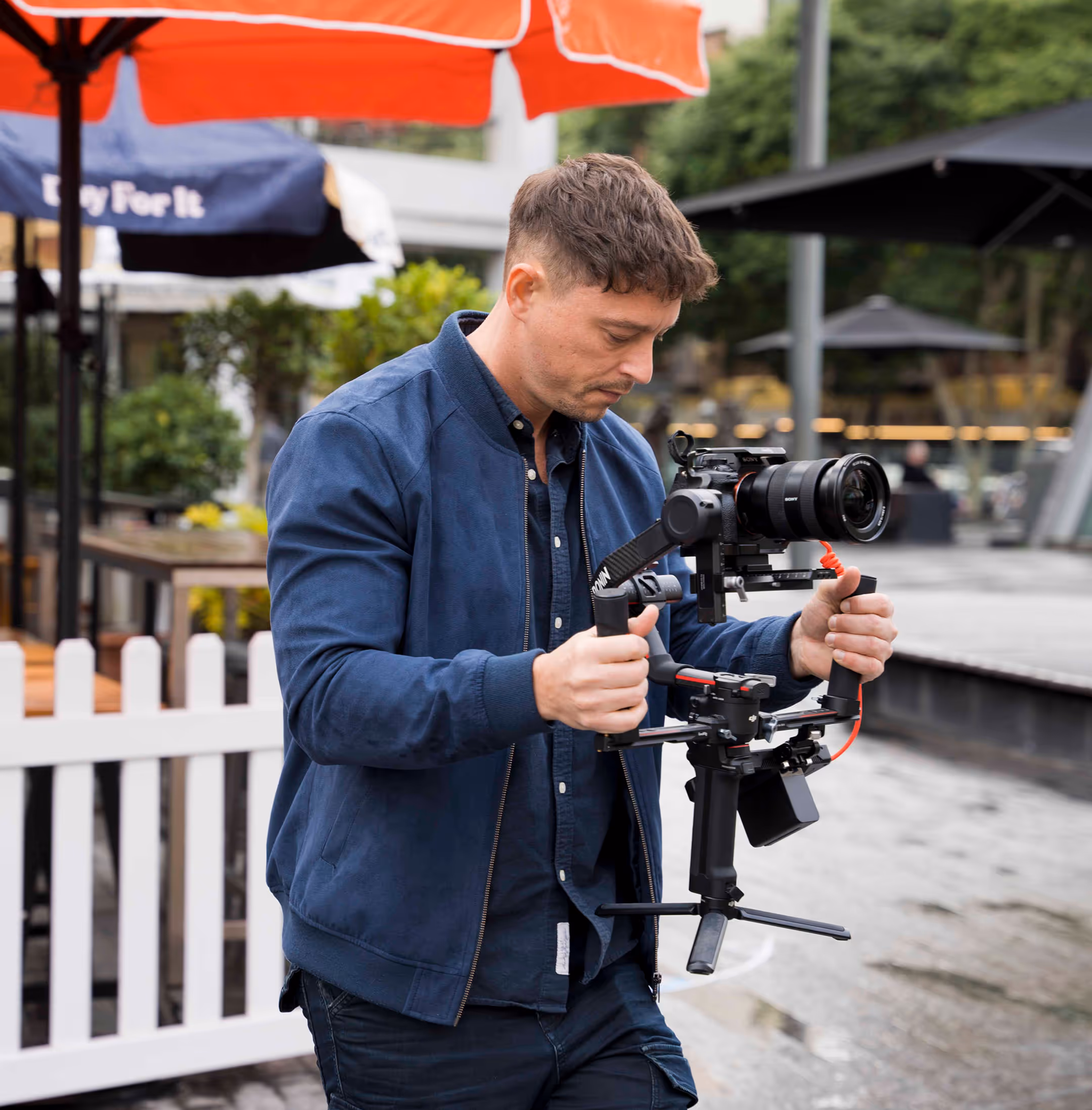Videographer filming a branded commercial video with talent in a studio environment.