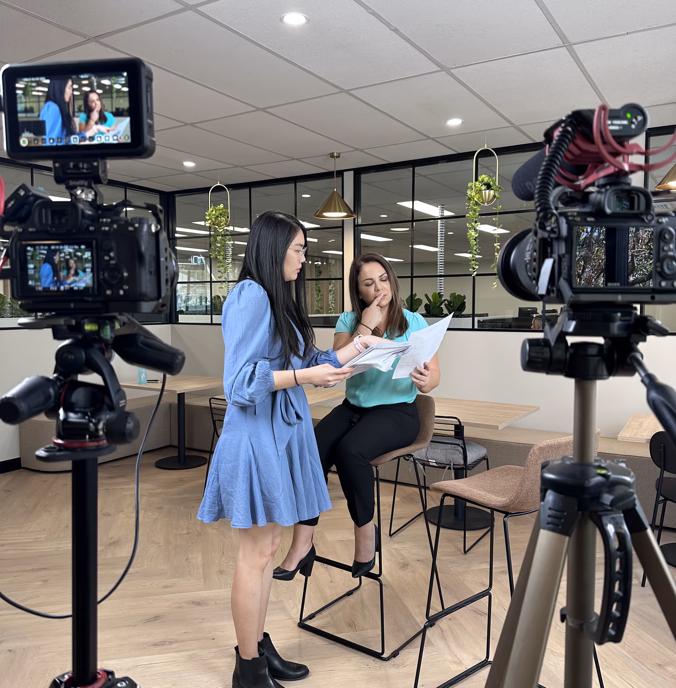 Videographer filming a branded commercial video with talent in a studio environment.