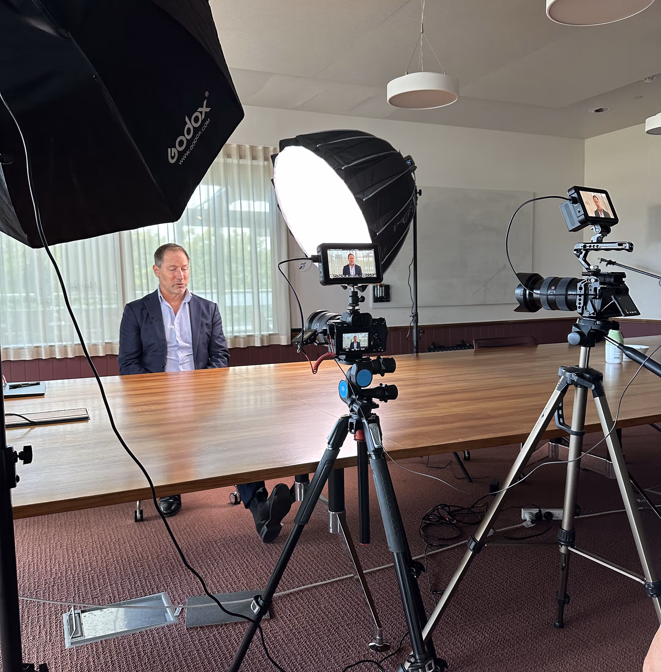 Photographer setting up professional lighting for a corporate studio session in Brisbane.