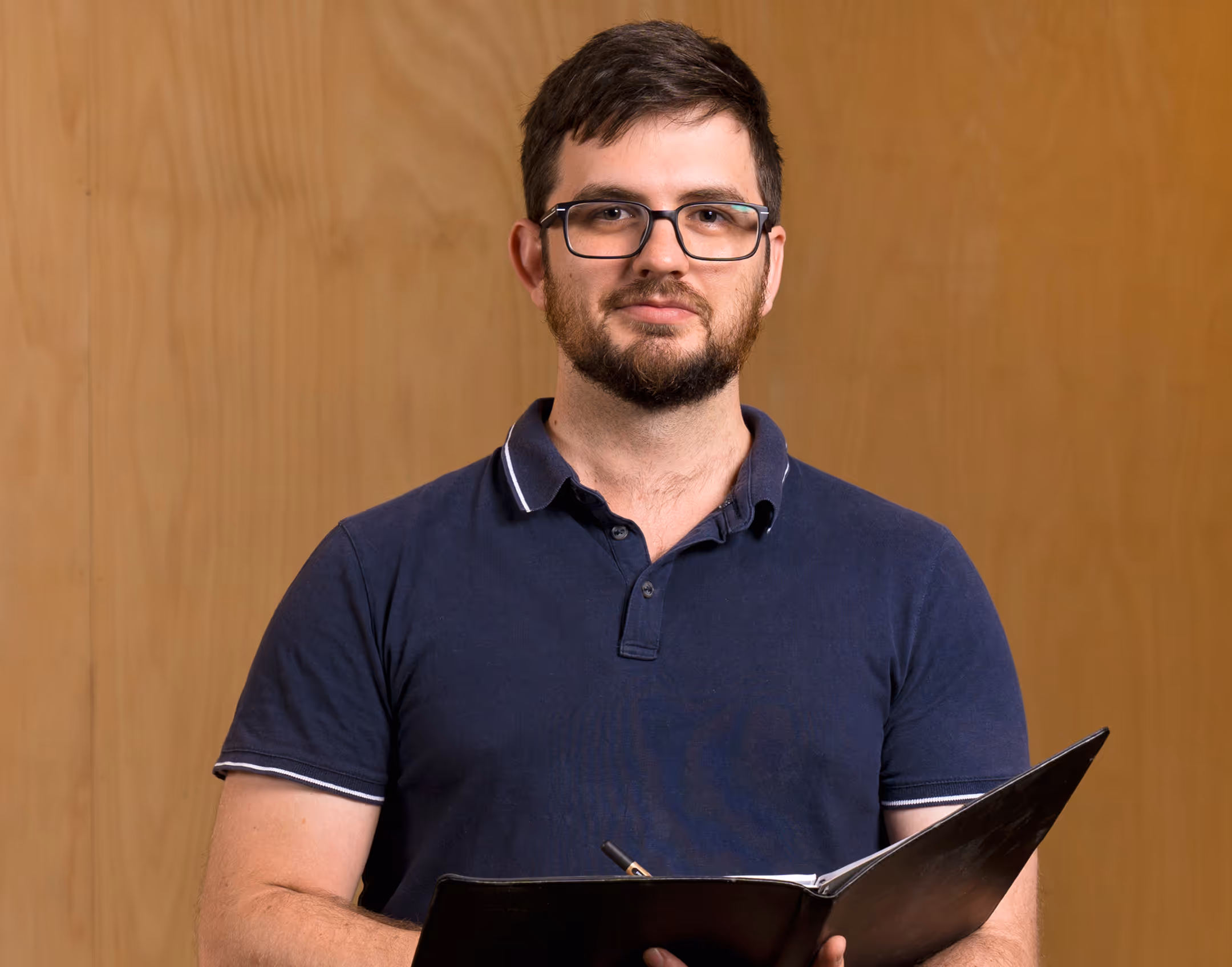 A photo of man a booking book in his hand.