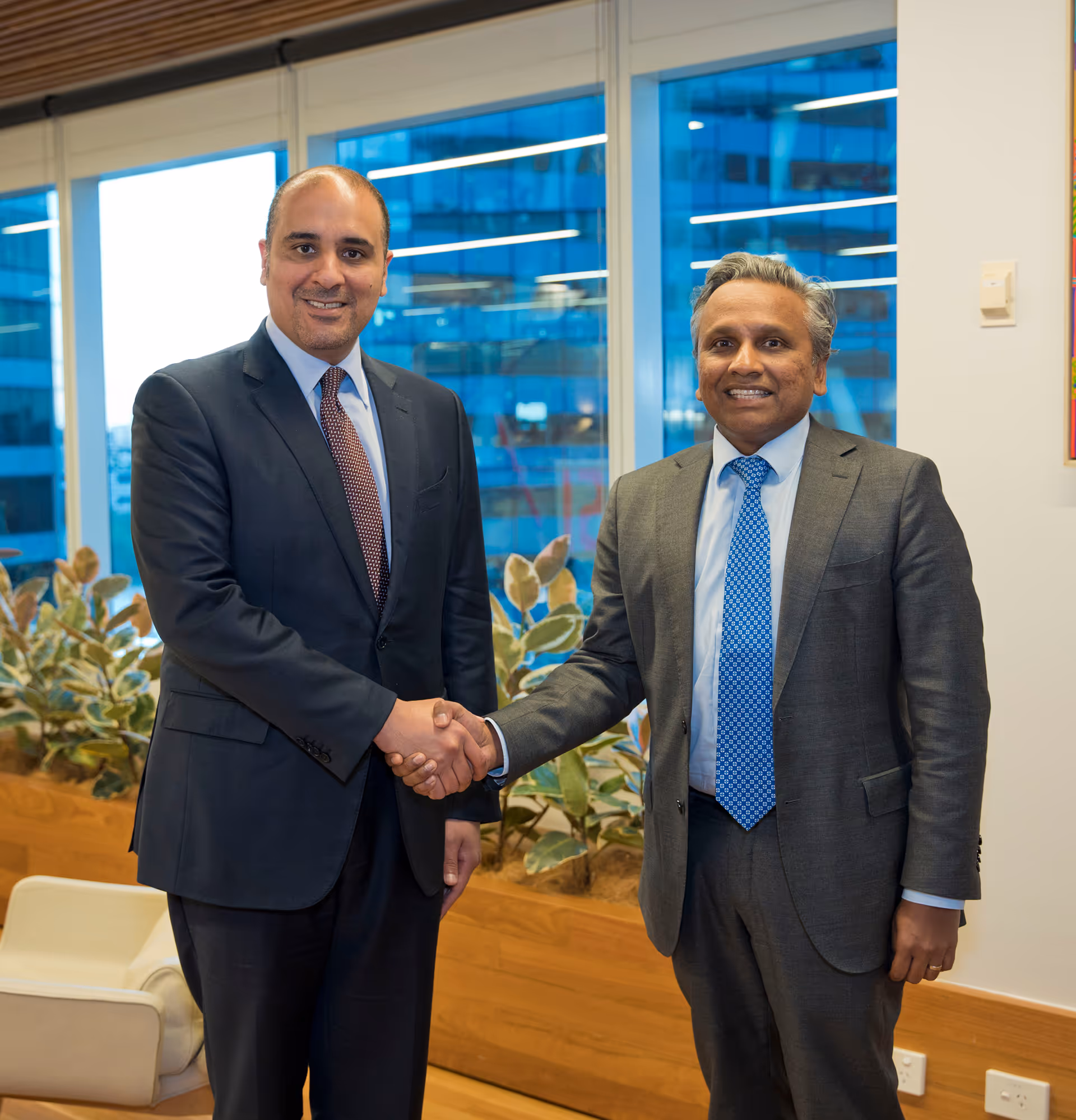 Business professionals shaking hands in a corporate meeting, symbolizing successful partnerships.