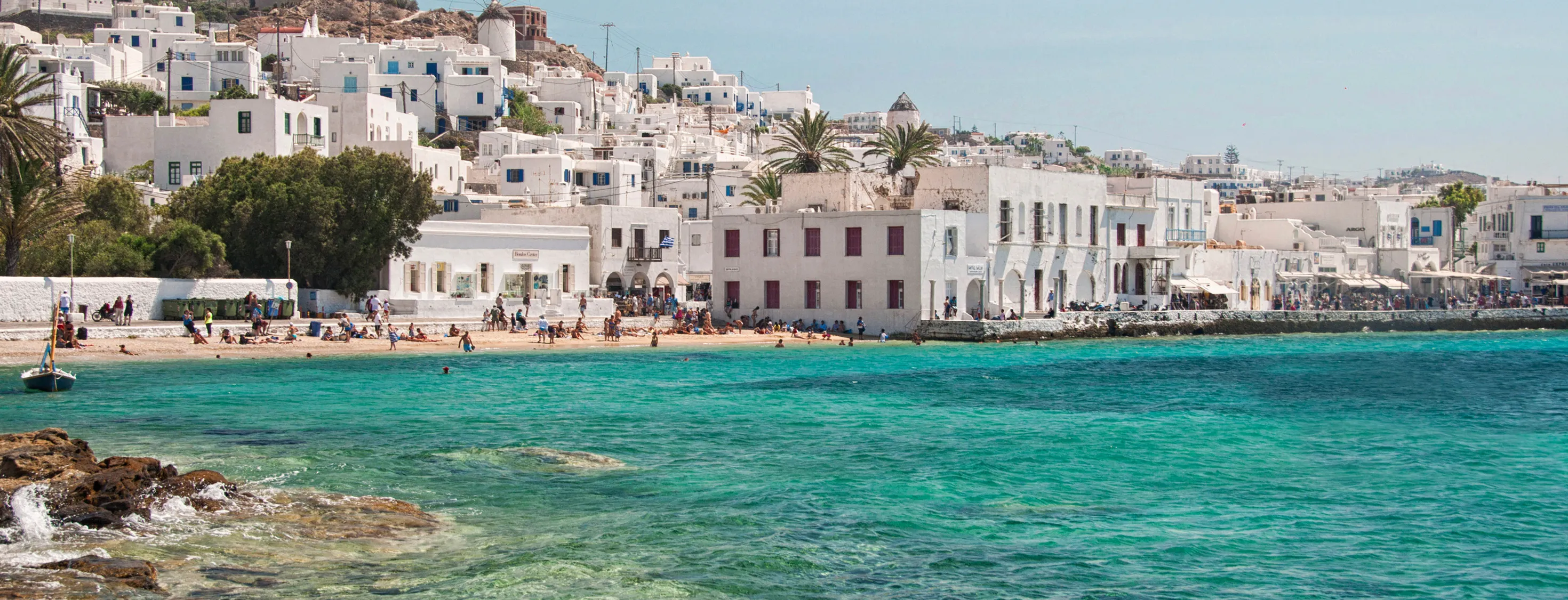 A Beautiful view of a sea from the corner of it while people are enjoying there.