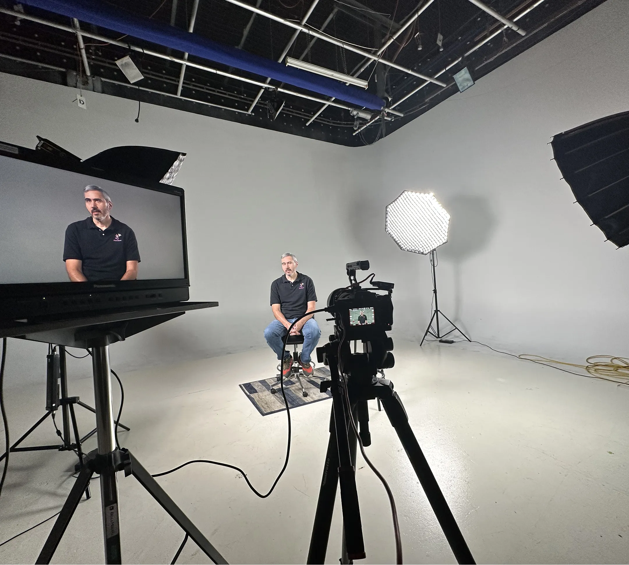 A man recording a video while sitting in a video production room.