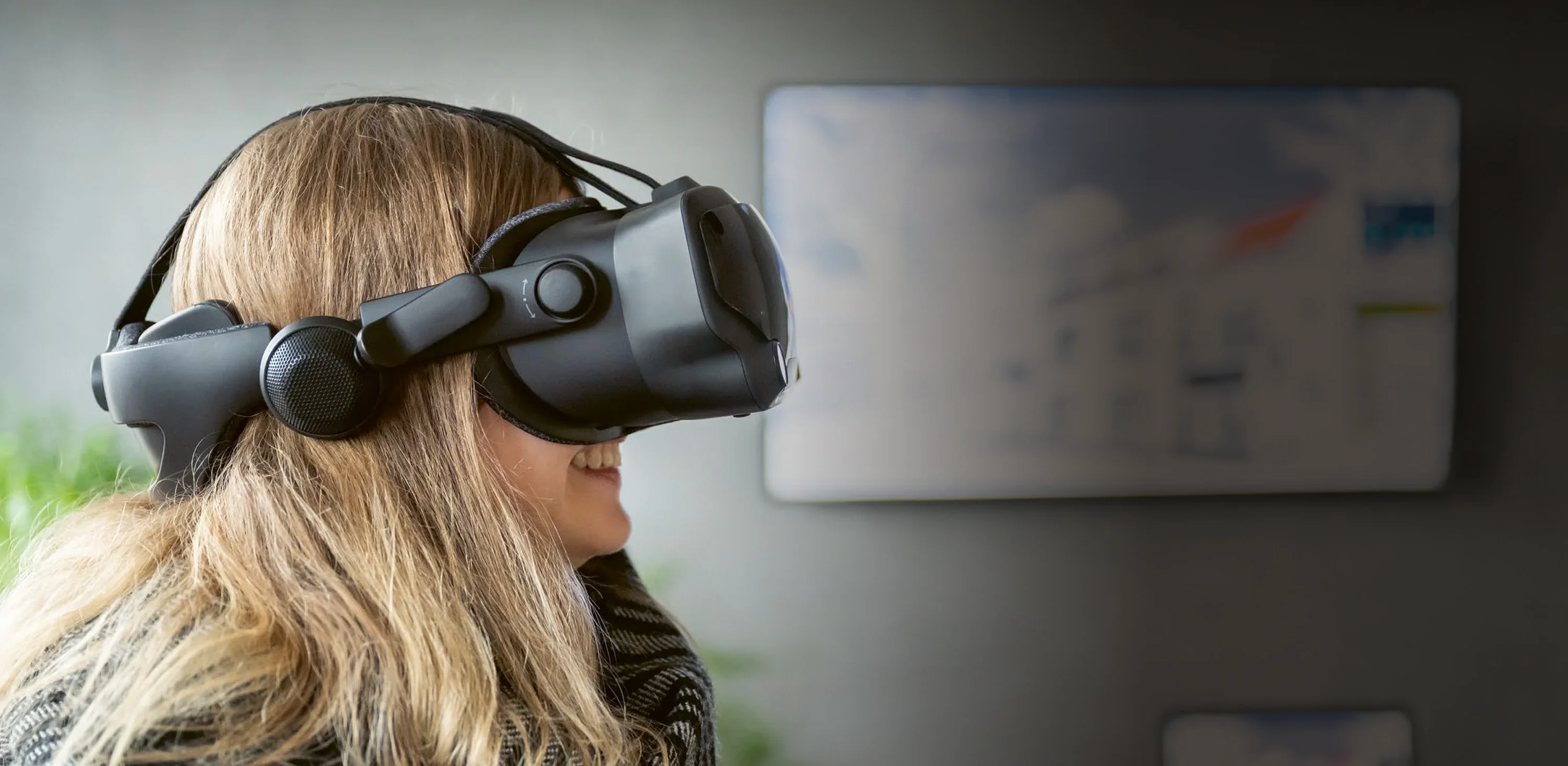 Junge Frau mit Virtual-Reality-Brille auf dem Kopf.