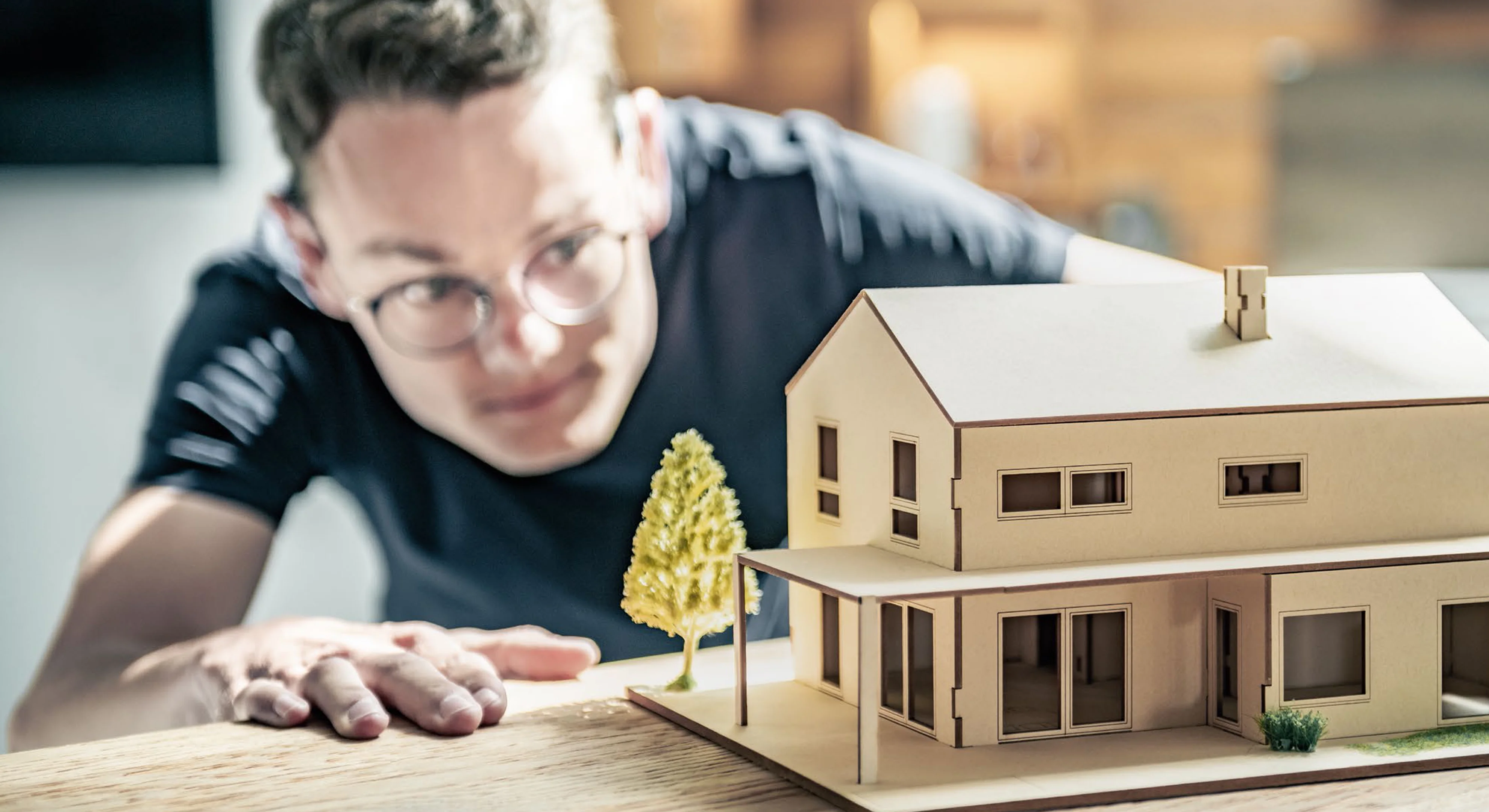 Interessent betrachtet Hausmodell von HAUSER Massivbau.