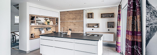 Innenansicht Küche mit Küchenblock und Holzelementen.