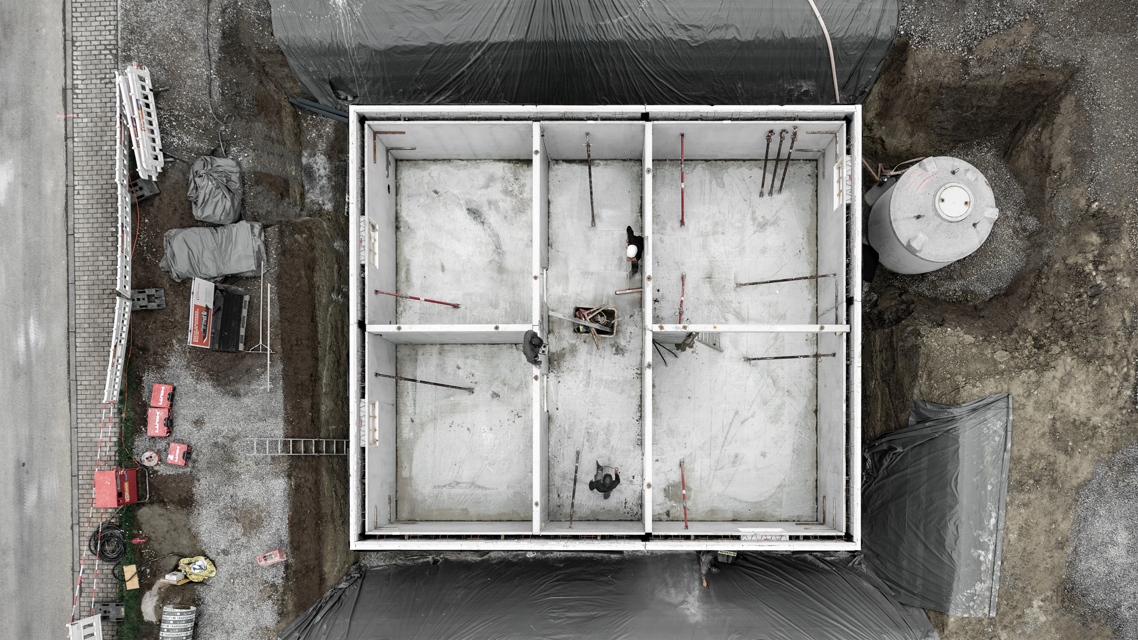 Drohnenaufnahme einer Baustelle mit Sicht auf bereits errichteten Keller.