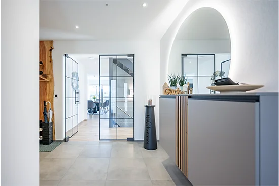 Eingangsbereich mit beleuchtetem Spiegel und Loft-Türe.