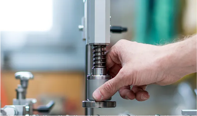 Hand hält ein Maschinenteil in Maschine