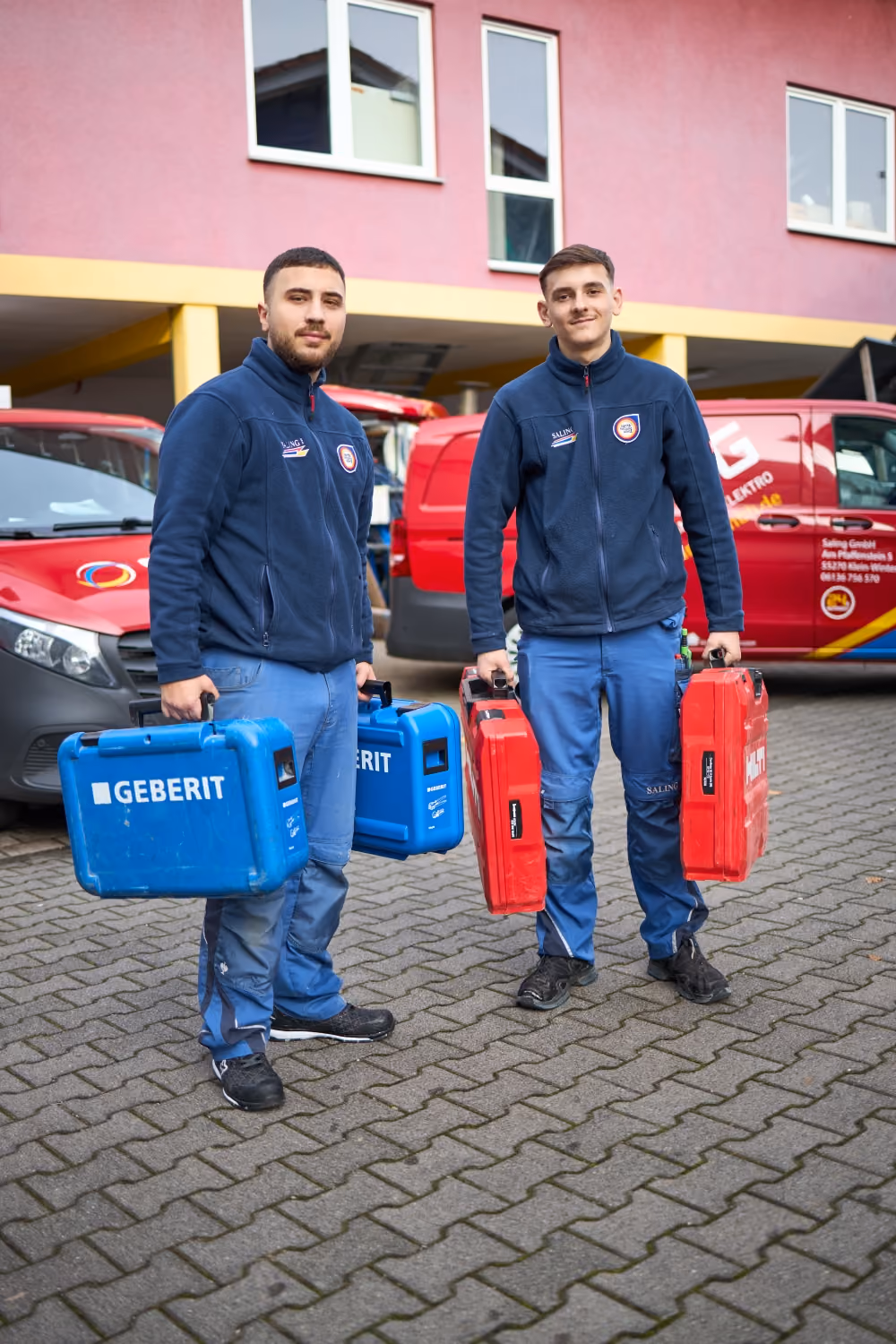 Zwei junge Saling Handwerker mit Werkzeugkoffern