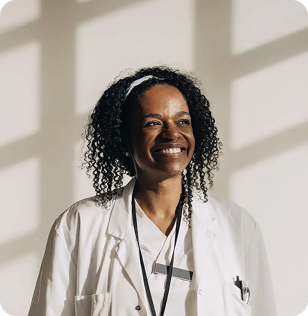 A smiling woman in a white lab coat.