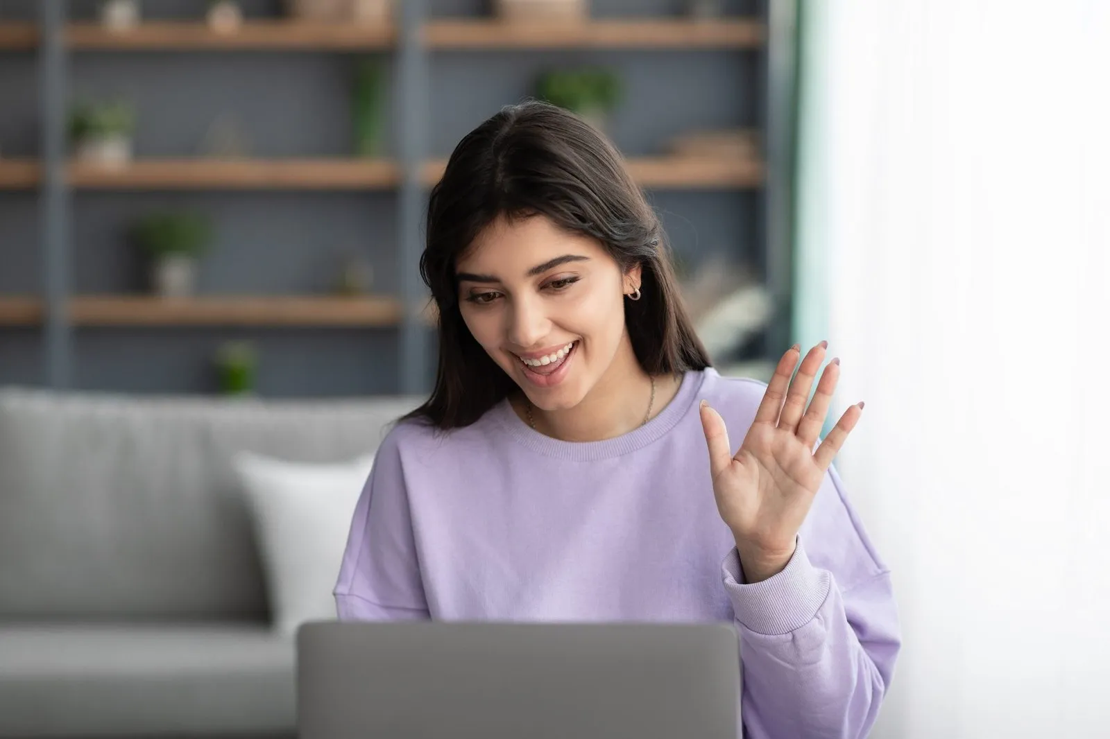 woman talking on video chat with hand raised