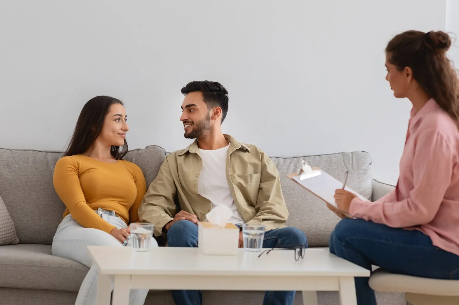 couple in appointment staring at each other happy while professional listens