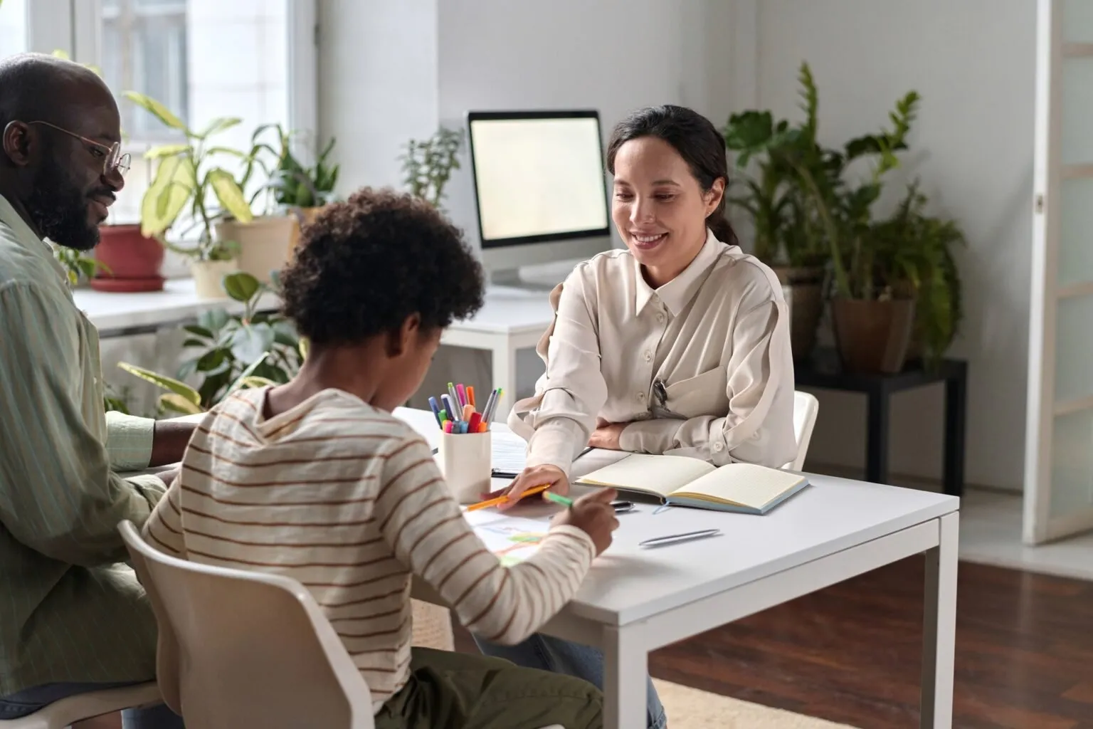 psychologist women speaking to black teen and father