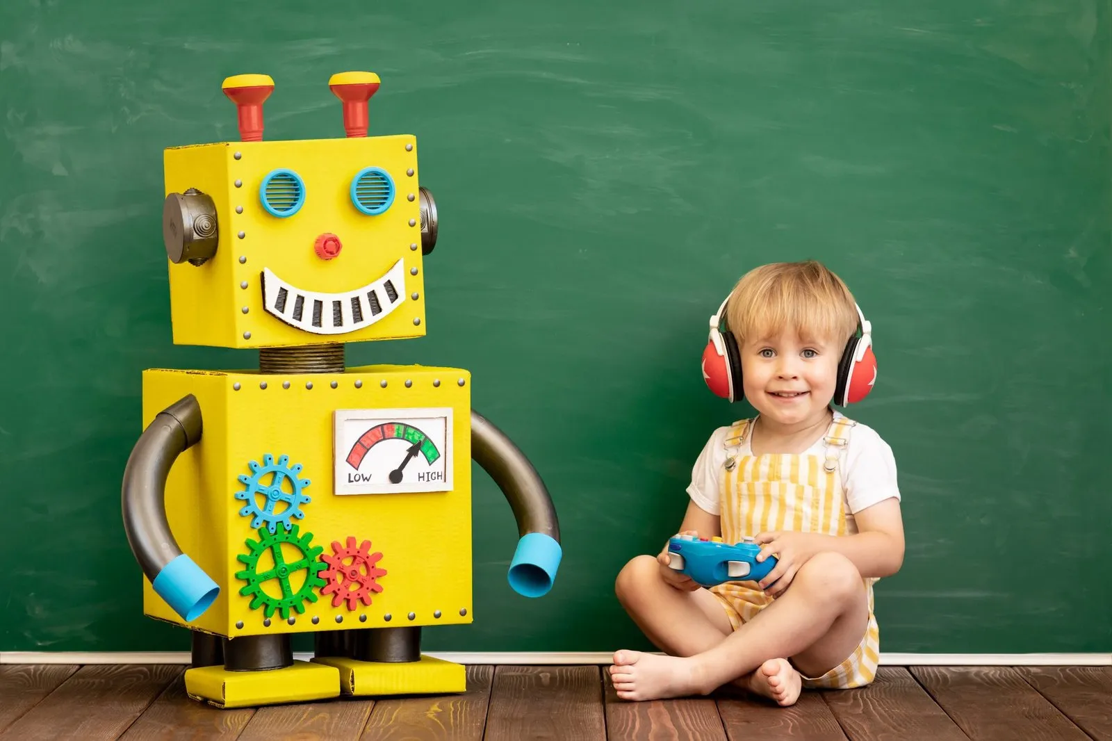 a child sitting next to a toy robot