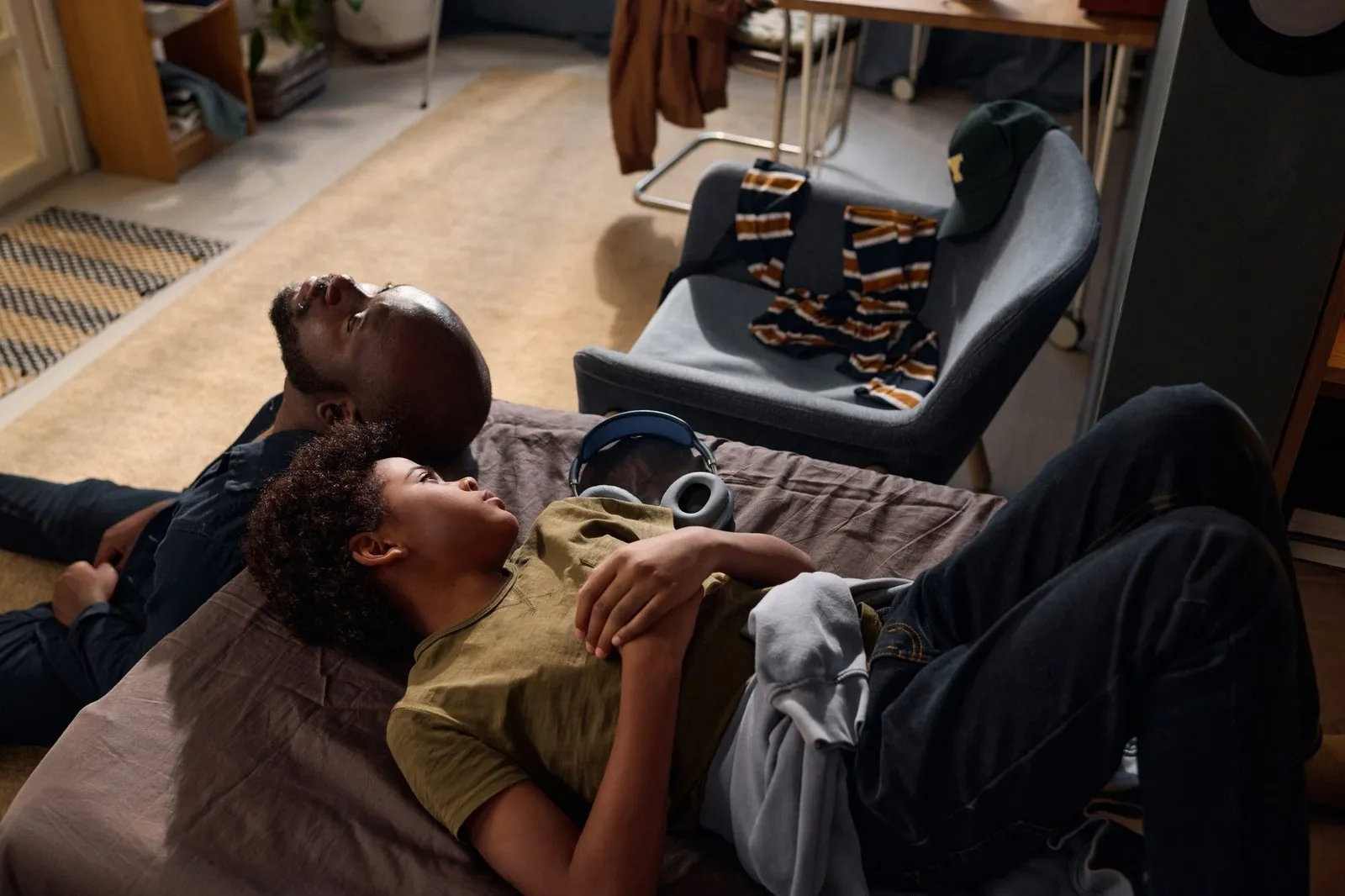 a man and a boy lying on a bed