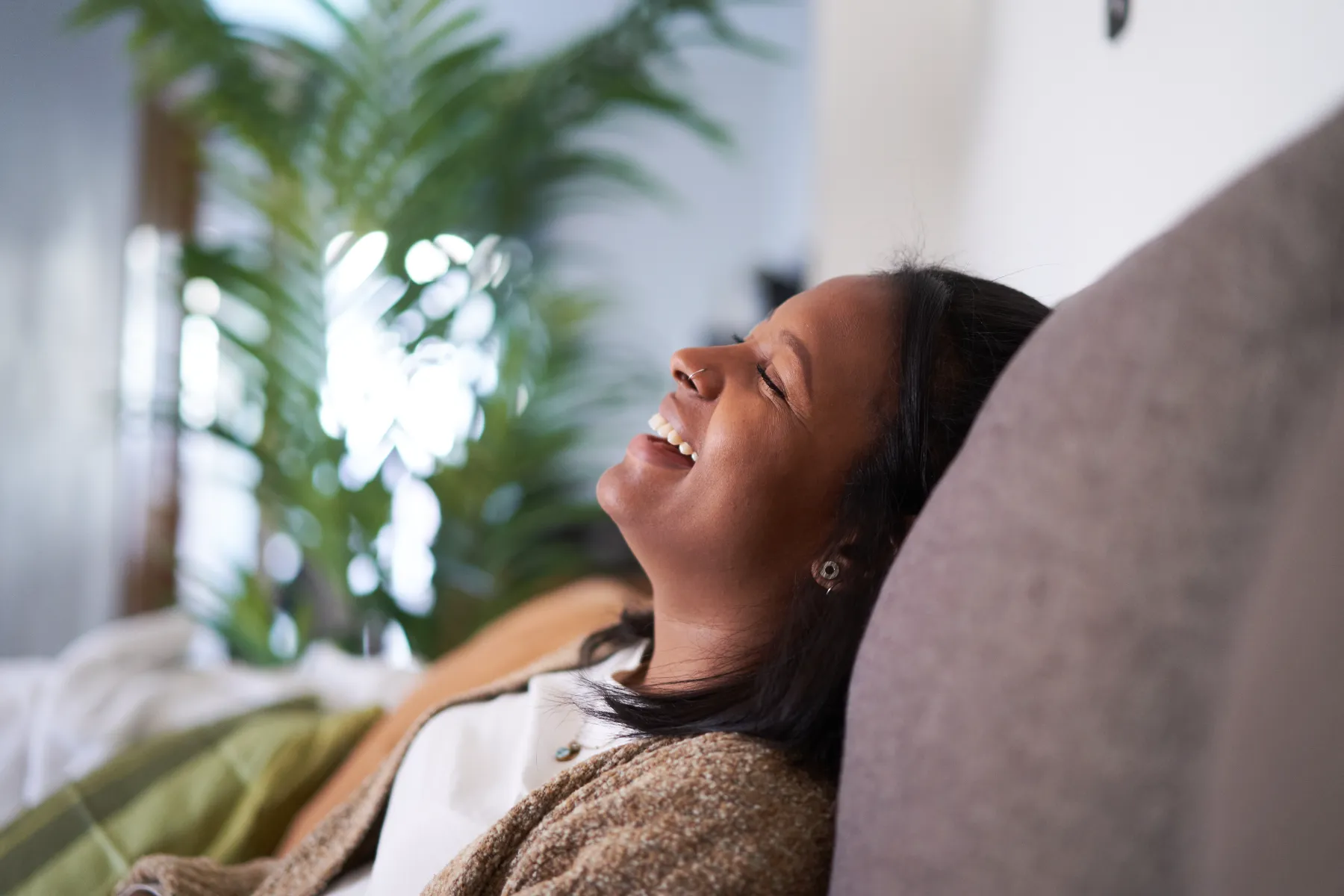 a woman smiling and sitting on a couch
