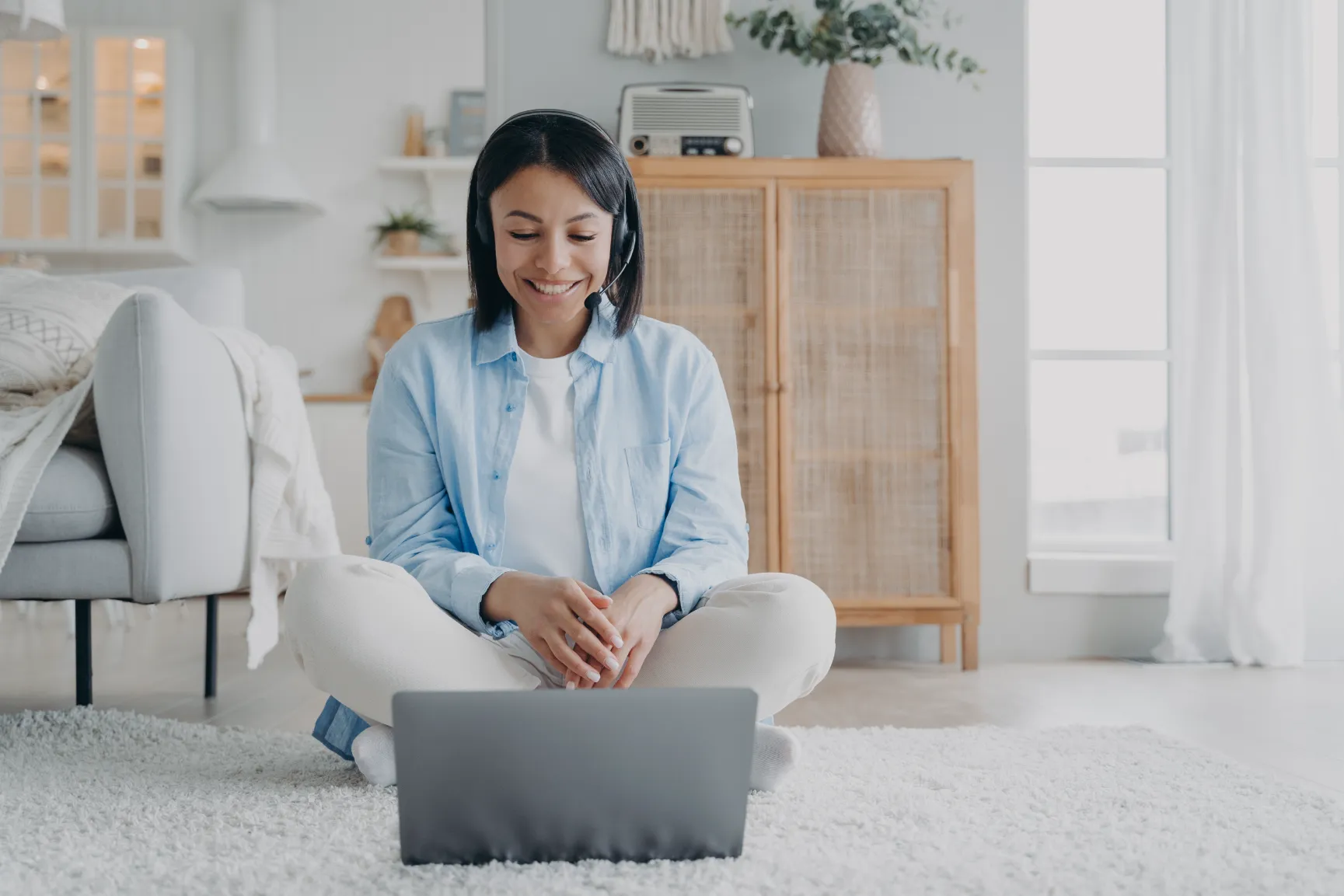 a woman sitting on the floor with a laptop