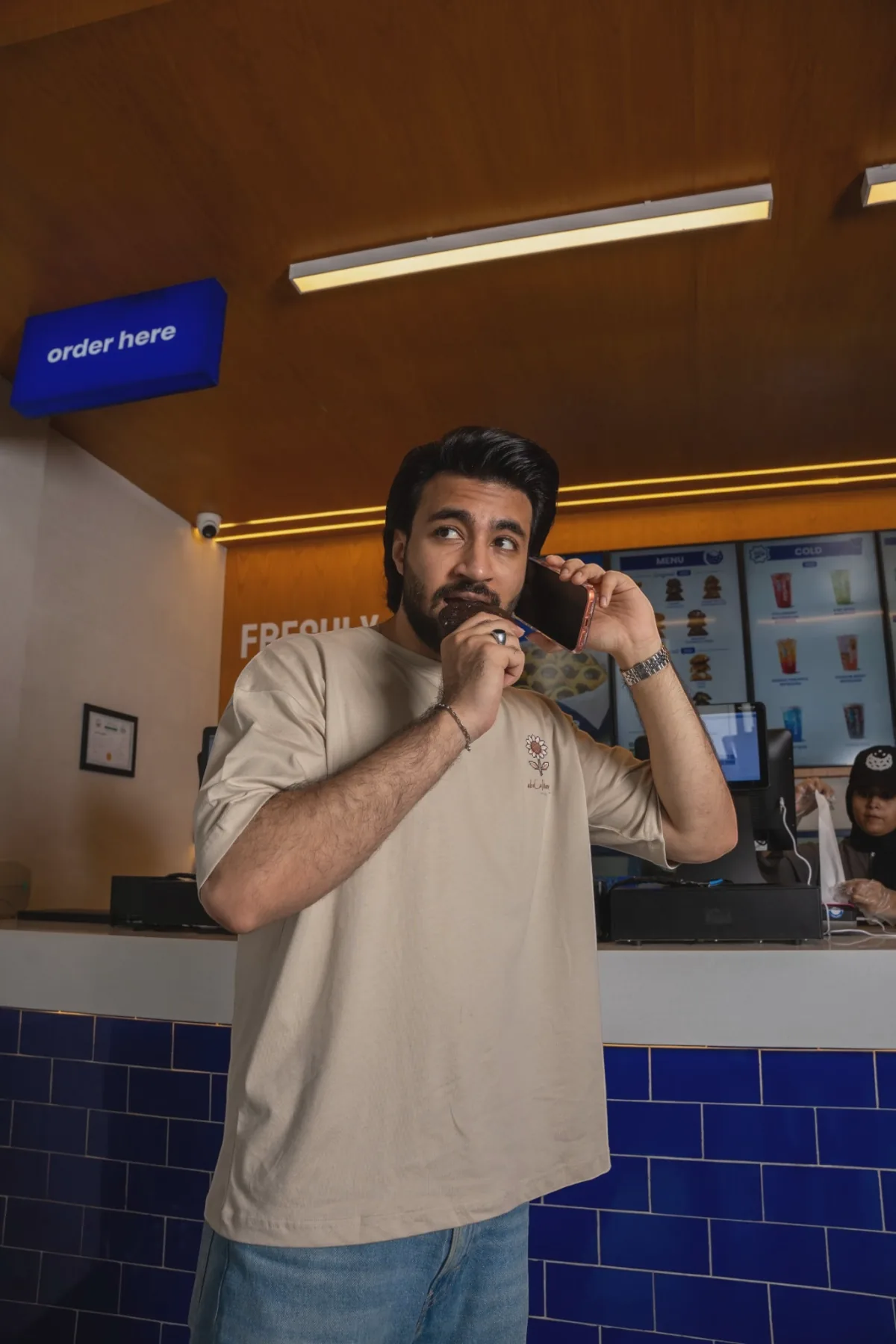 Abdul Hannan at the Crumble counter, wearing the collaboration tee