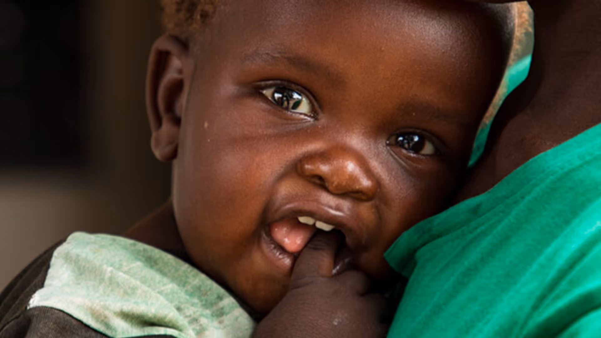 Enfant qui met les mains dans sa bouche