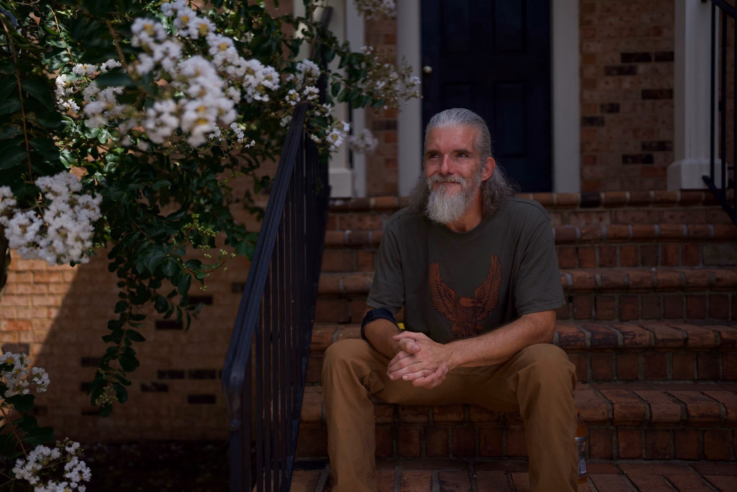Person smiling while sitting on their front steps