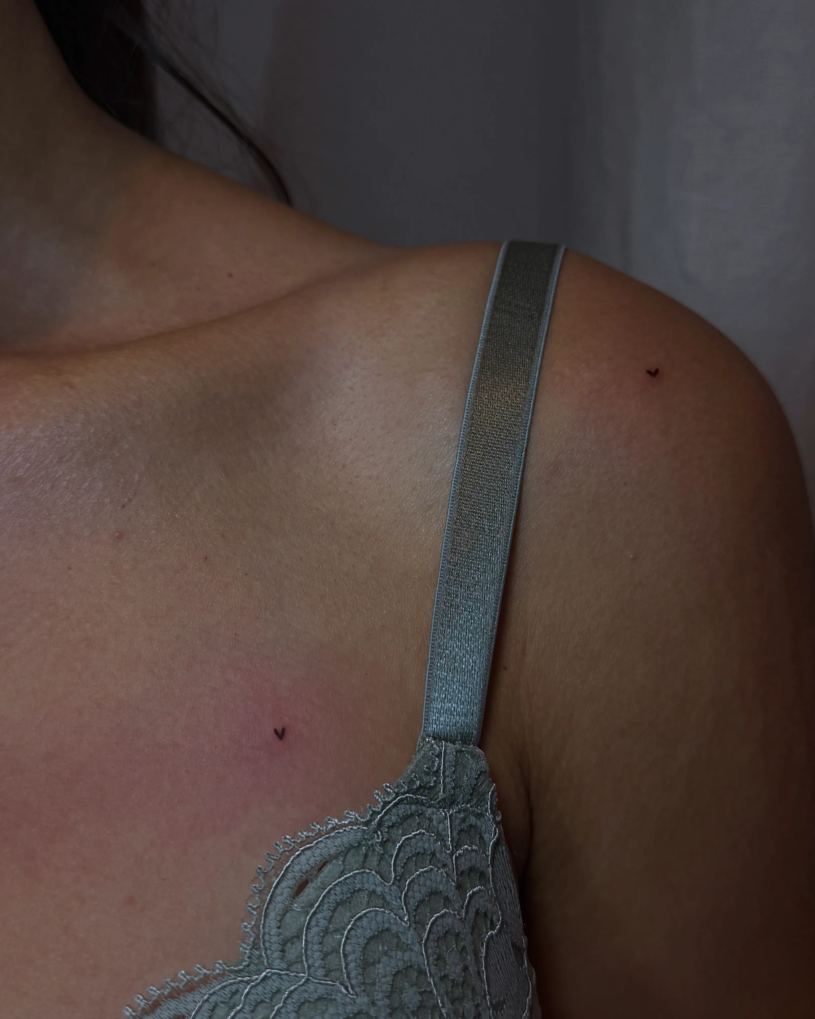 Mini-Tattoo in Herzform auf der oberen Brust