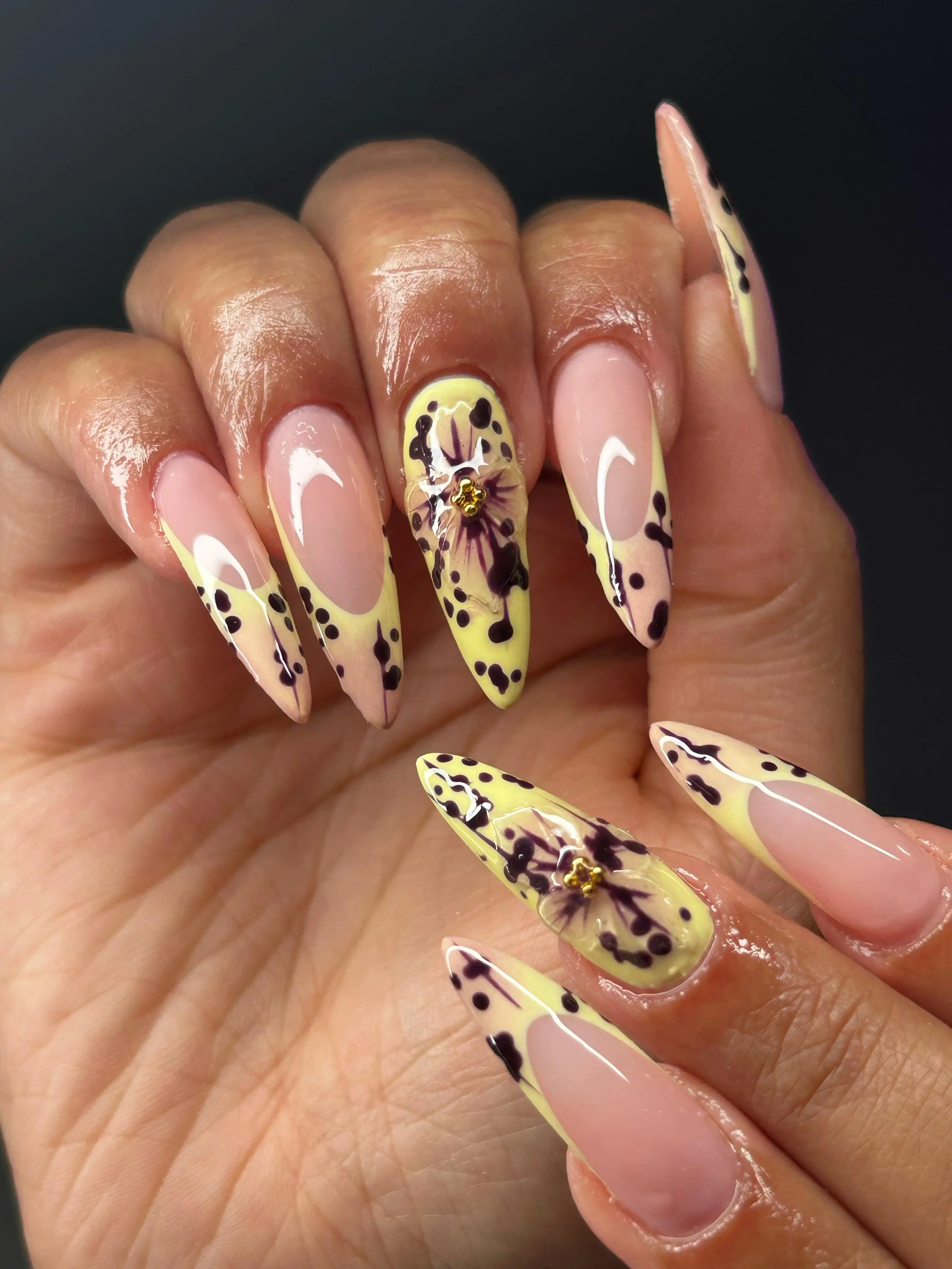 Detailaufnahme von Fingernägeln mit rosa-gelbem Nailart und schwarzen Verzierungen – professionell gestylt bei I AM A PRIORITY.