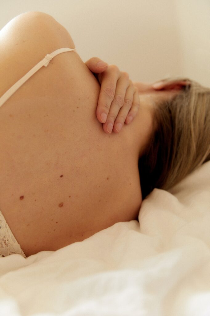 Back of woman in bed suffering from menopause with blonde hair
