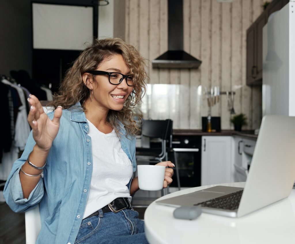 Women with curly hair taking a video call in her kitchen