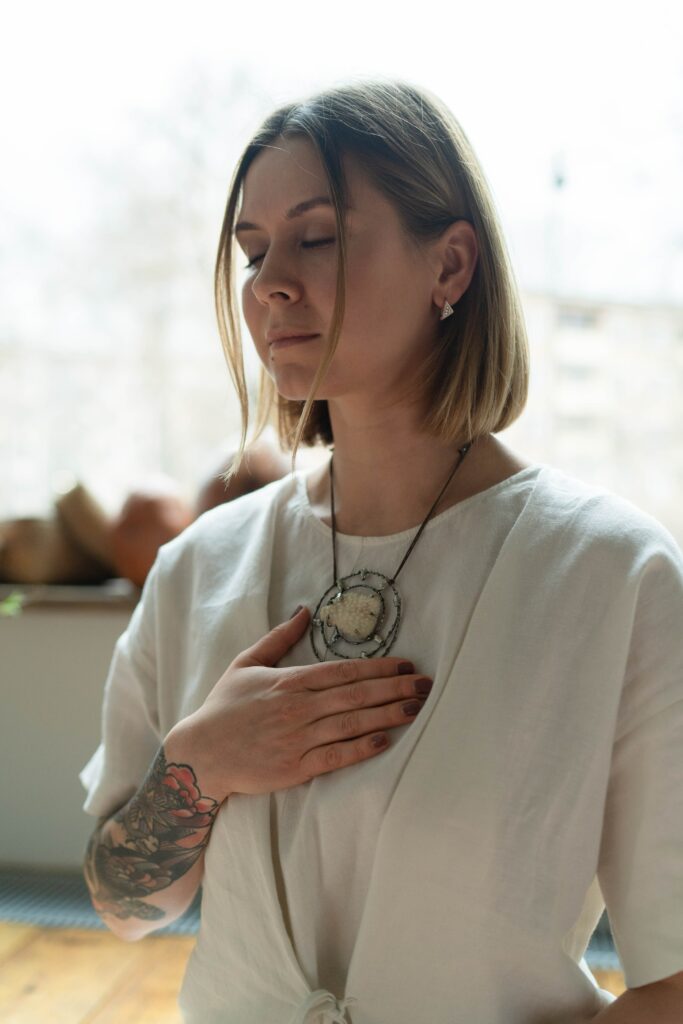 A woman with her eyes closed and hand placed lightly on her chest