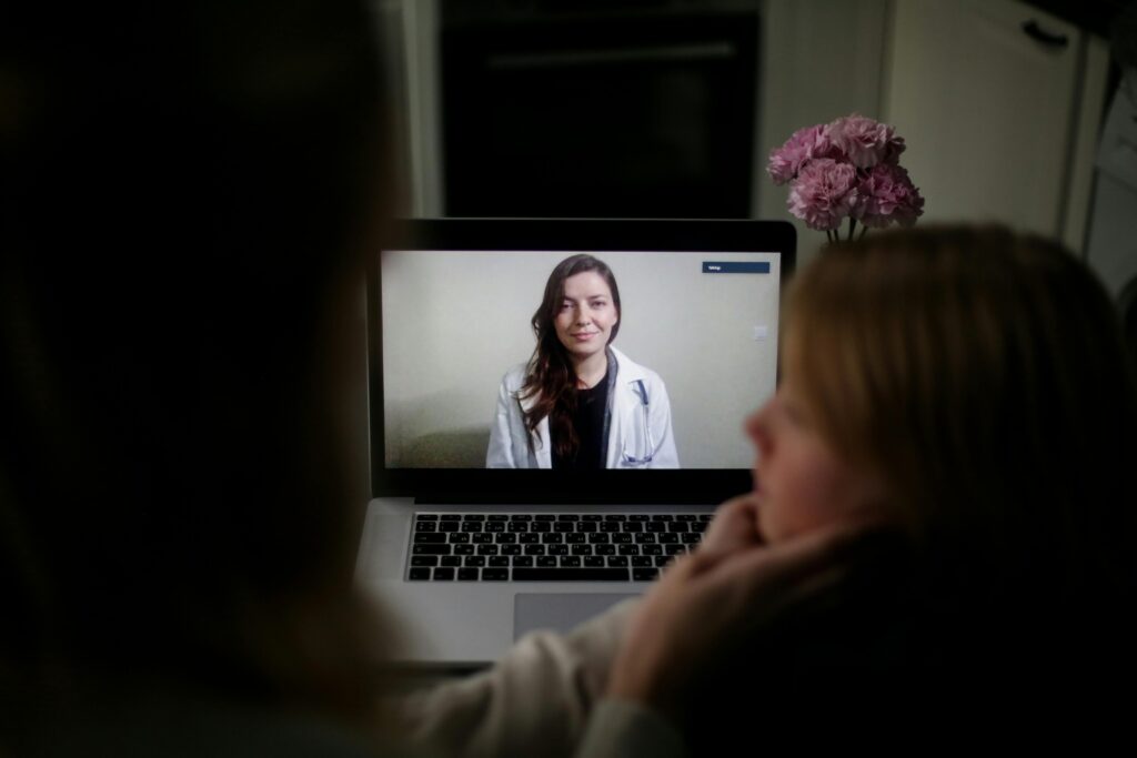 Patient care - A lady listens to a doctor through a virtual consultation