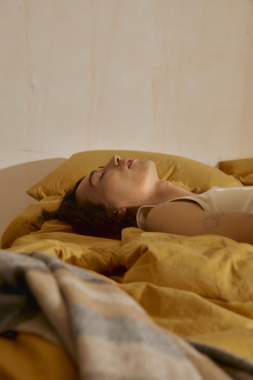 Women laid out on bed looking at ceiling
