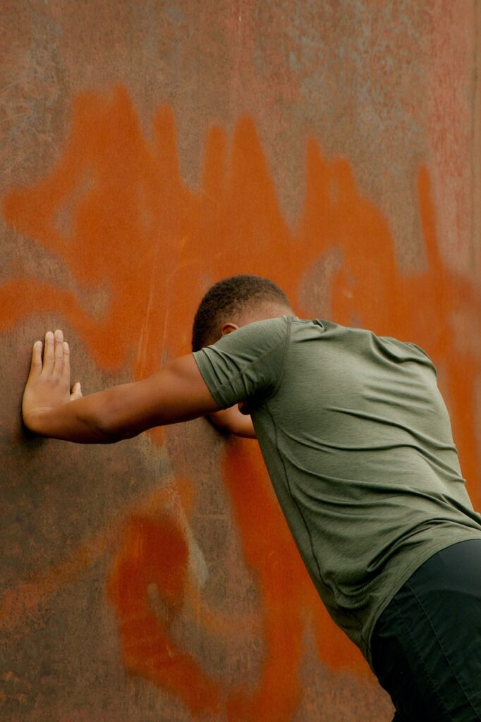 Man stretching against red wall with sportswear