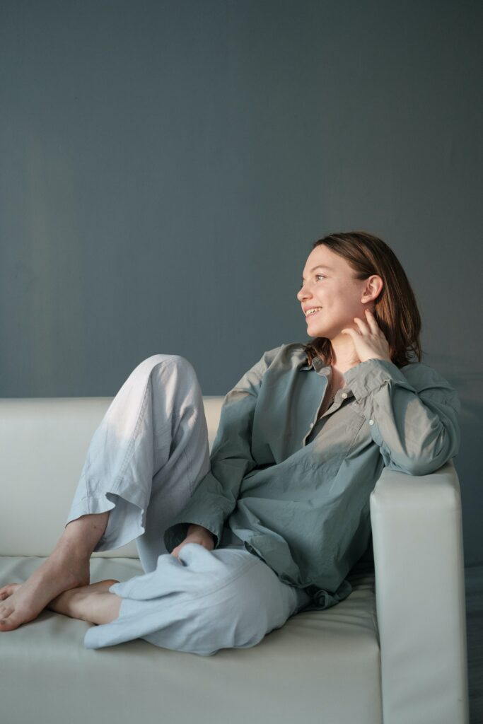 A woman sitting on a sofa looking happy