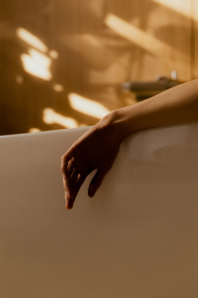 Women in bath with one arm over the bathtub relaxing