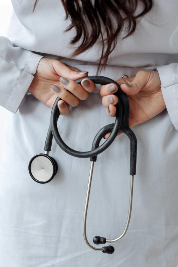 A doctor holding a stethoscope behind their back