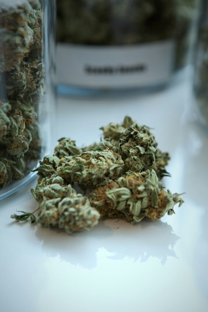 A few buds of cannabis flower placed on a white table.