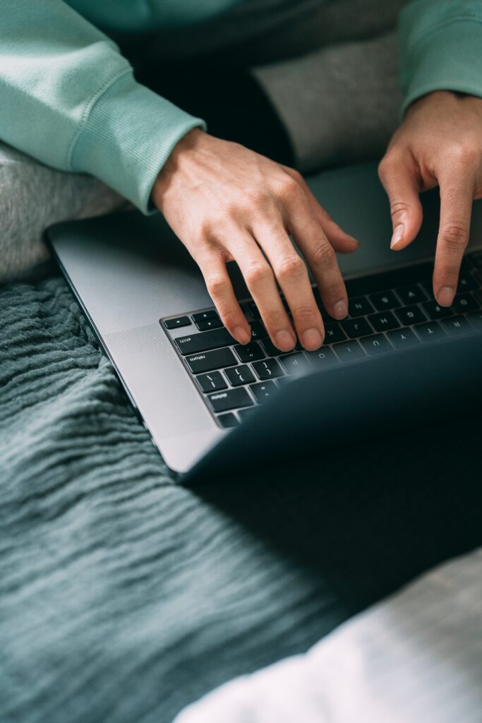 A person using a laptop in bed